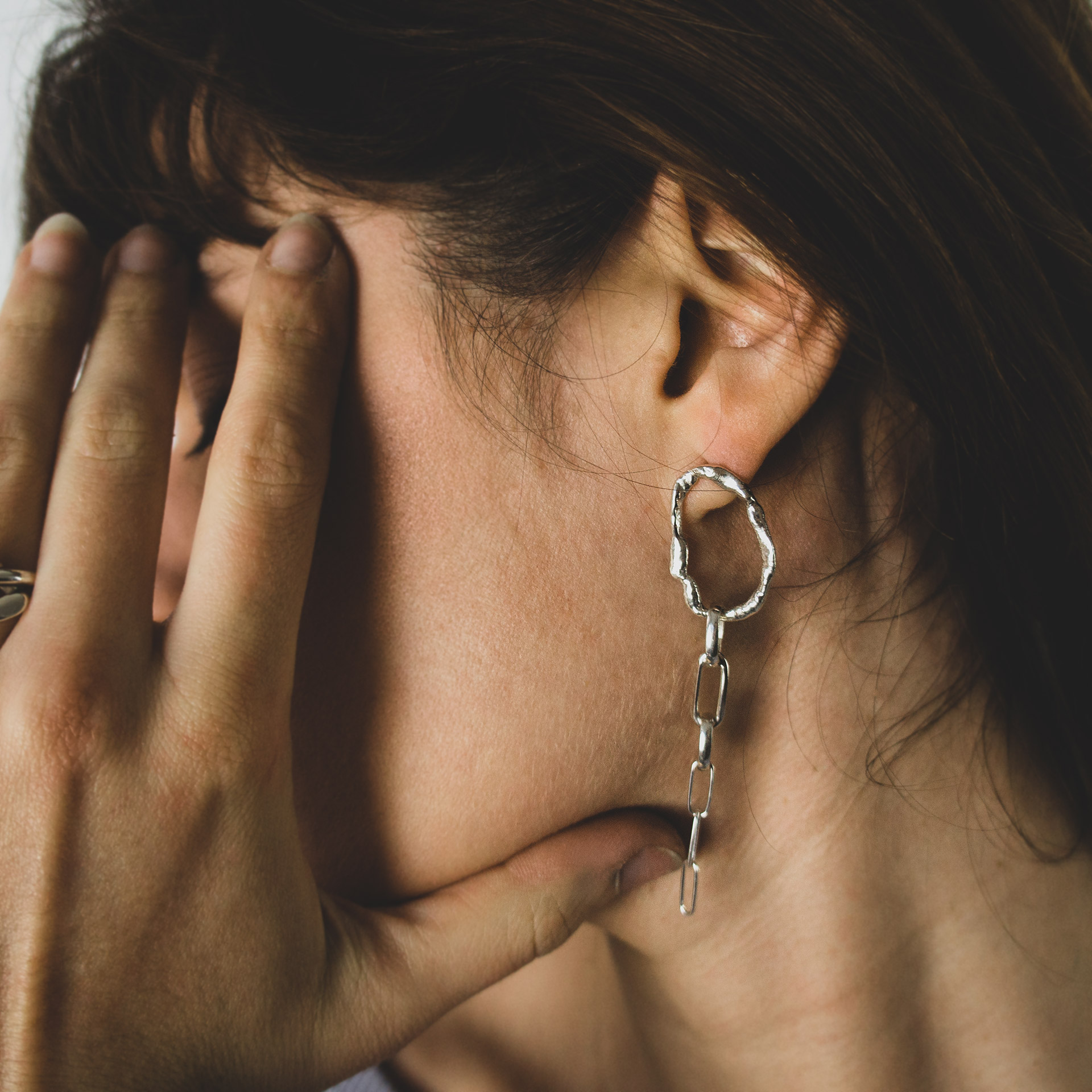 Fuyou long dangling earrings in silver with fluid oval shapes and chains.